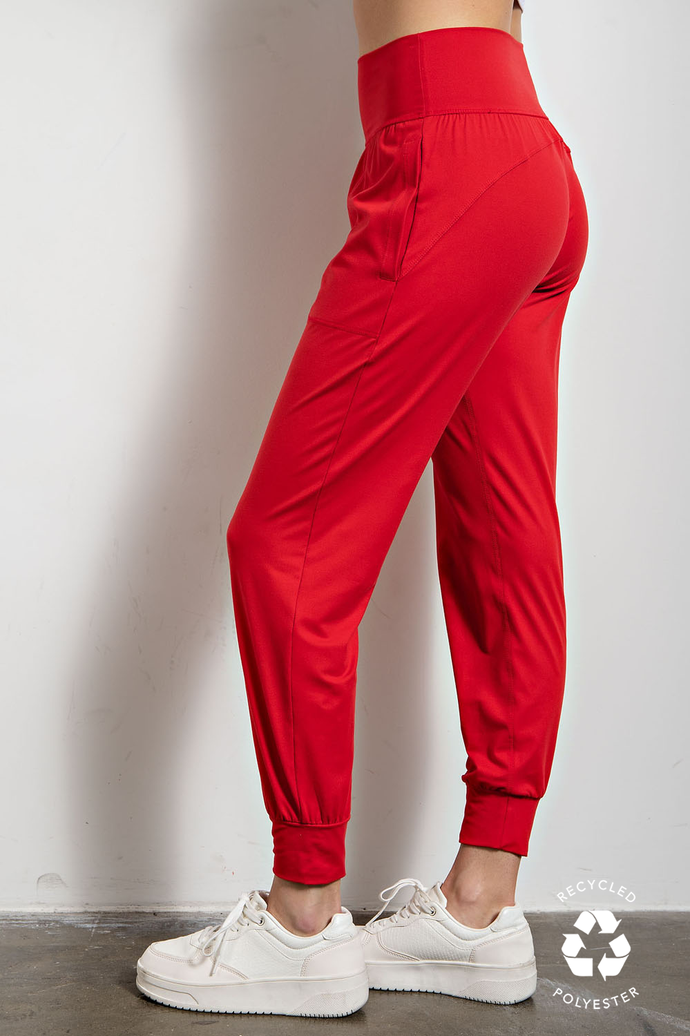 Red jogger pants worn by a woman on a plain background